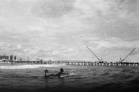 a black and white photo of a person on a surfboard in the ocean